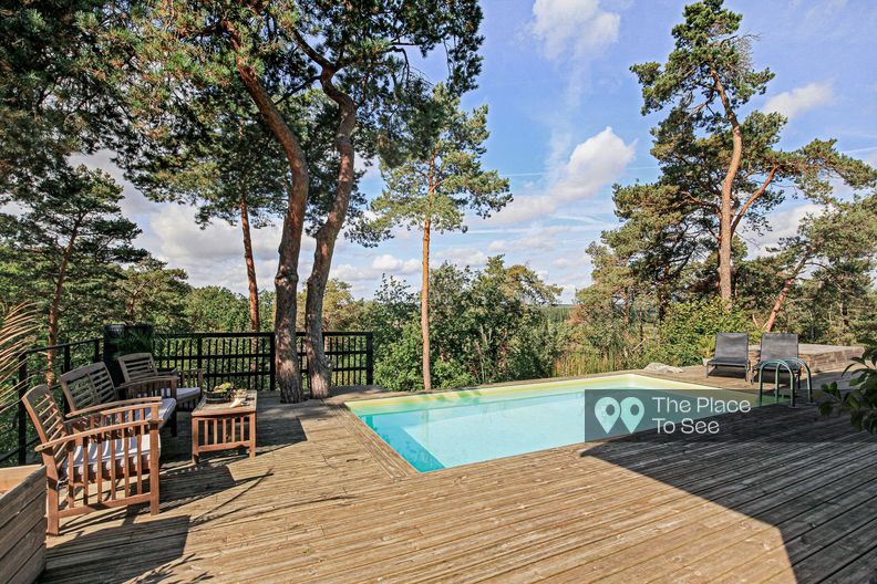 Maison d'architecte en bois et pierre dans la forêt