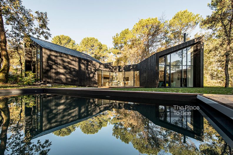 Maison d'architecte avec façade en bardage bois noir et piscine