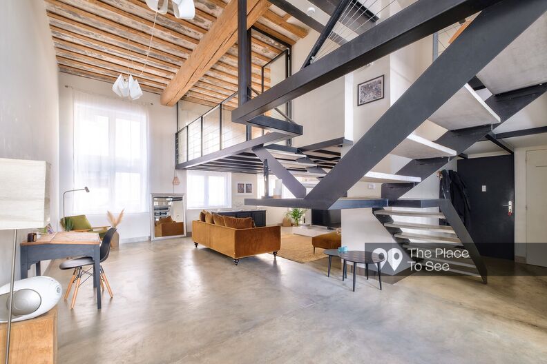 Old workshop rehabilitated into a loft with a concrete floor and exposed beams