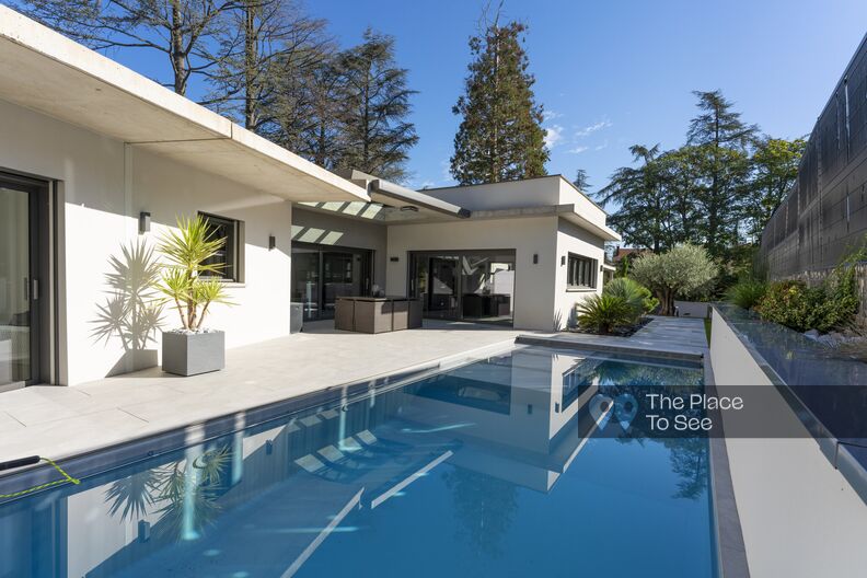 Maison d'architecte avec toit plat, jardin paysagé et piscine